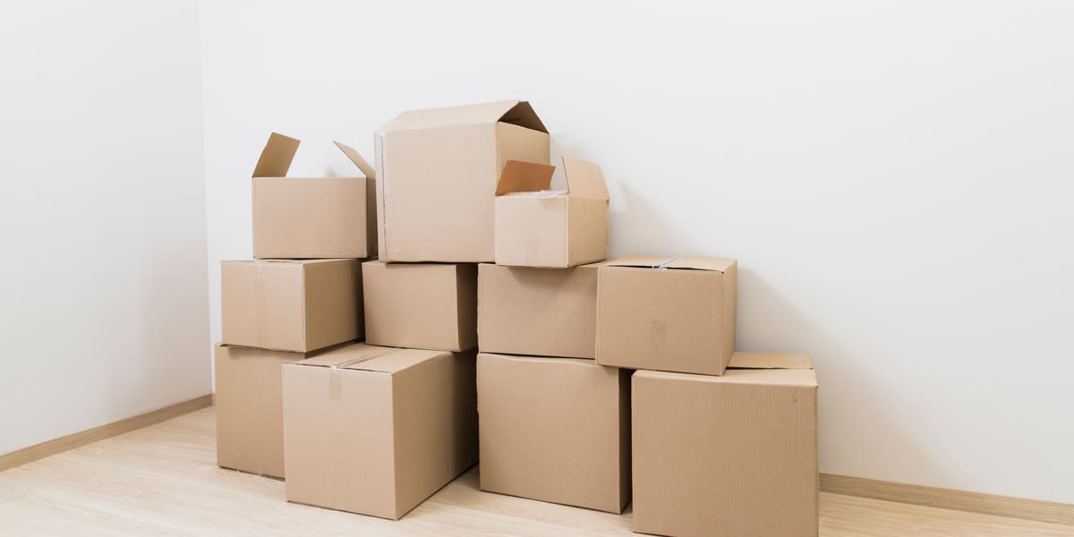 Cajas de mudanza apiladas en la esquina de una habitación vacía